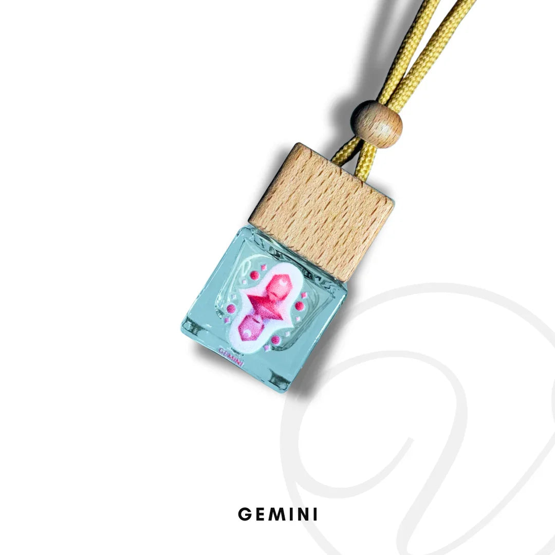 Gemini zodiac fragrance diffuser with wooden cap and pink Gemini symbol on blue glass bottle