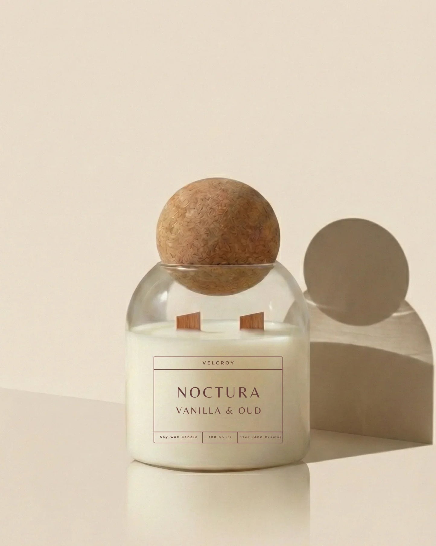 Vanilla and oud luxury soy candle in glass jar with wood lid on neutral background