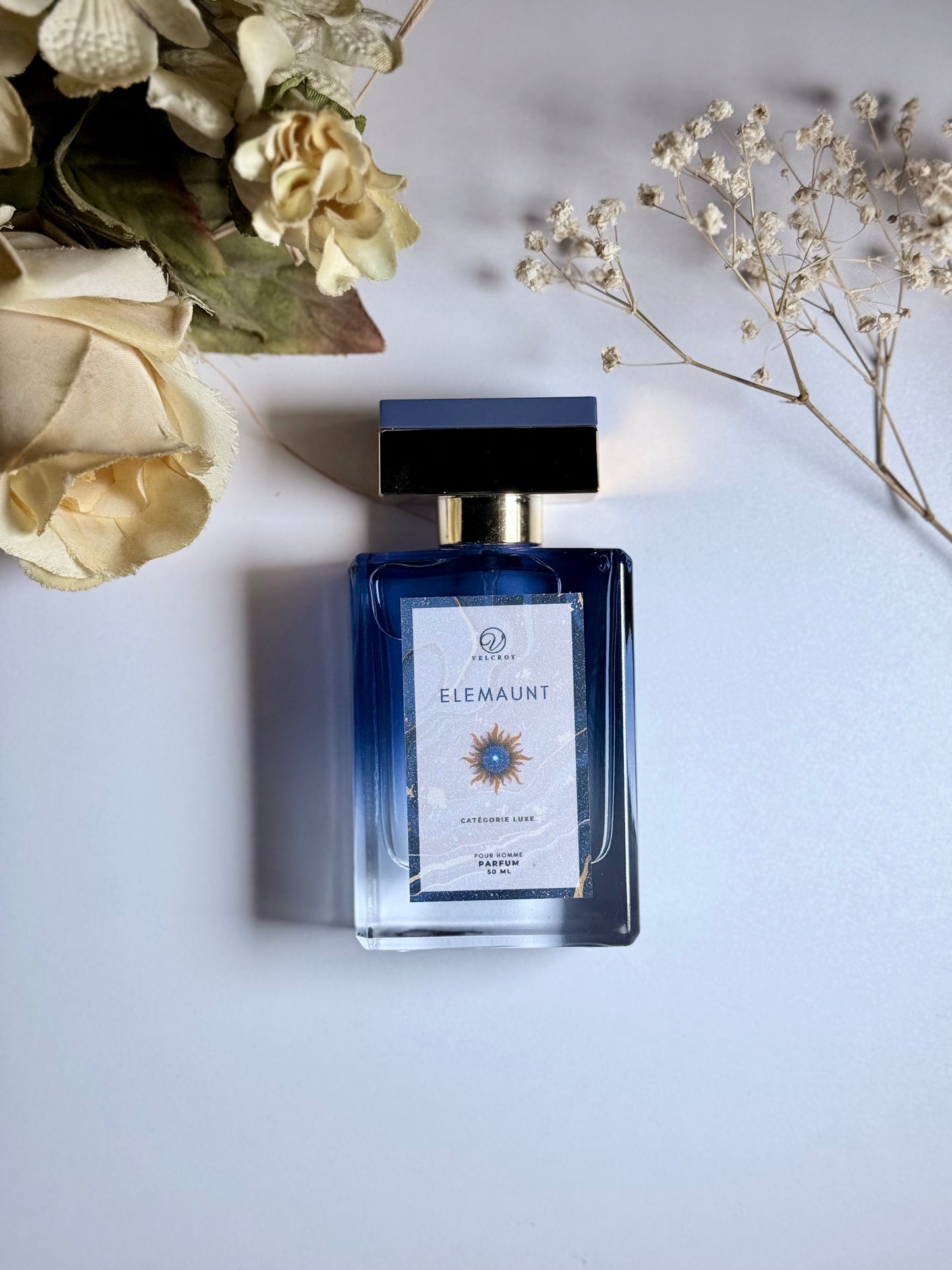 Perfume bottle labeled 'ELEMAUNT' with flowers on a light background