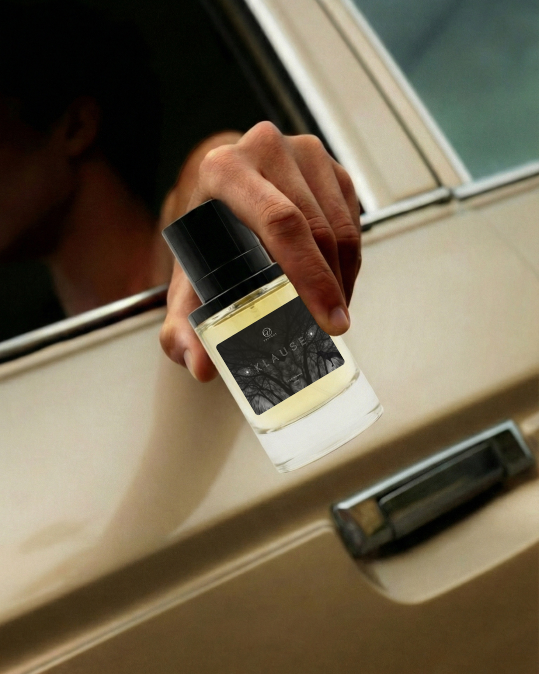 Hand holding luxury fragrance bottle with black label outside car window