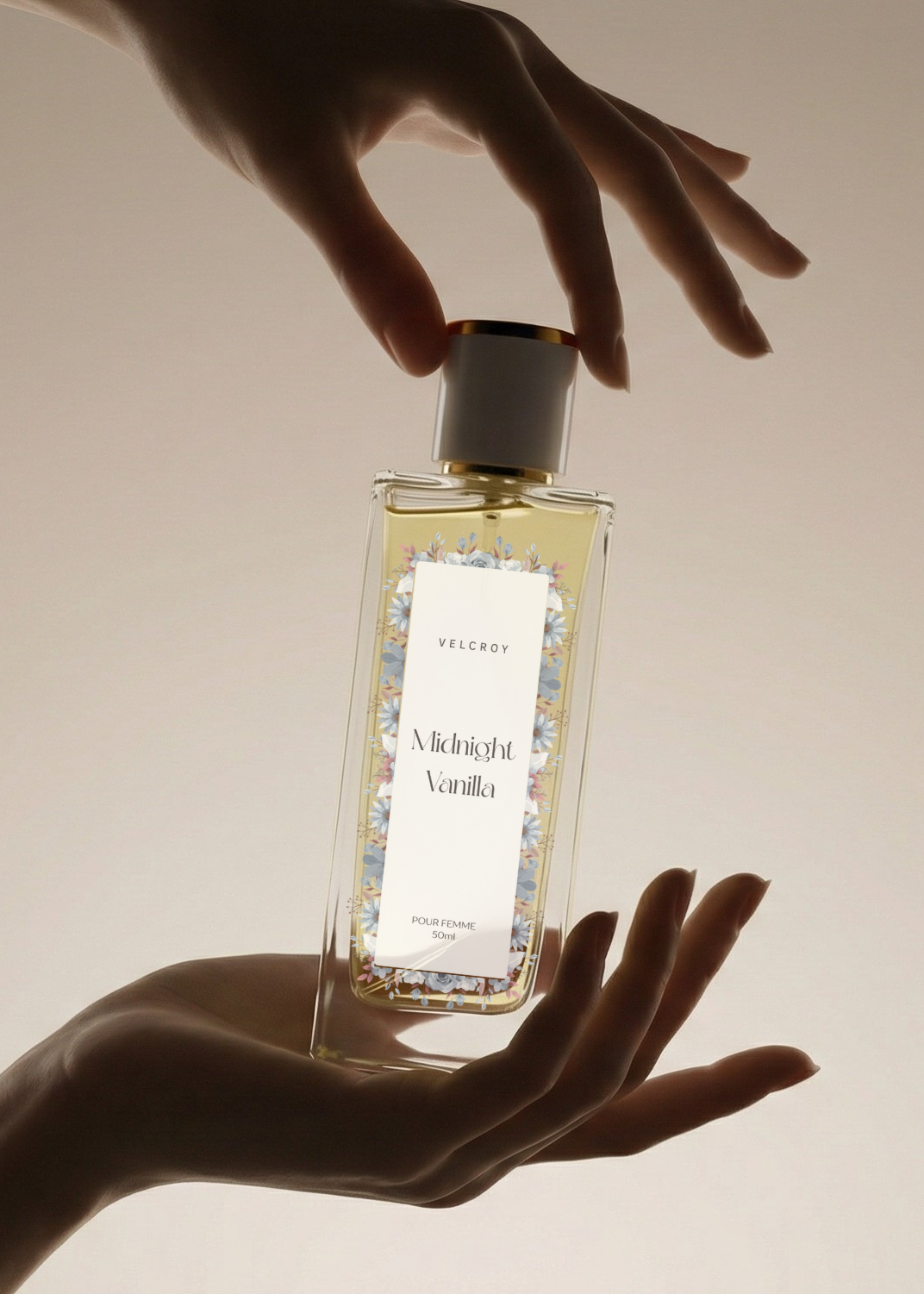 Elegant glass bottle of Midnight Vanilla perfume held by graceful hands, floral label visible.