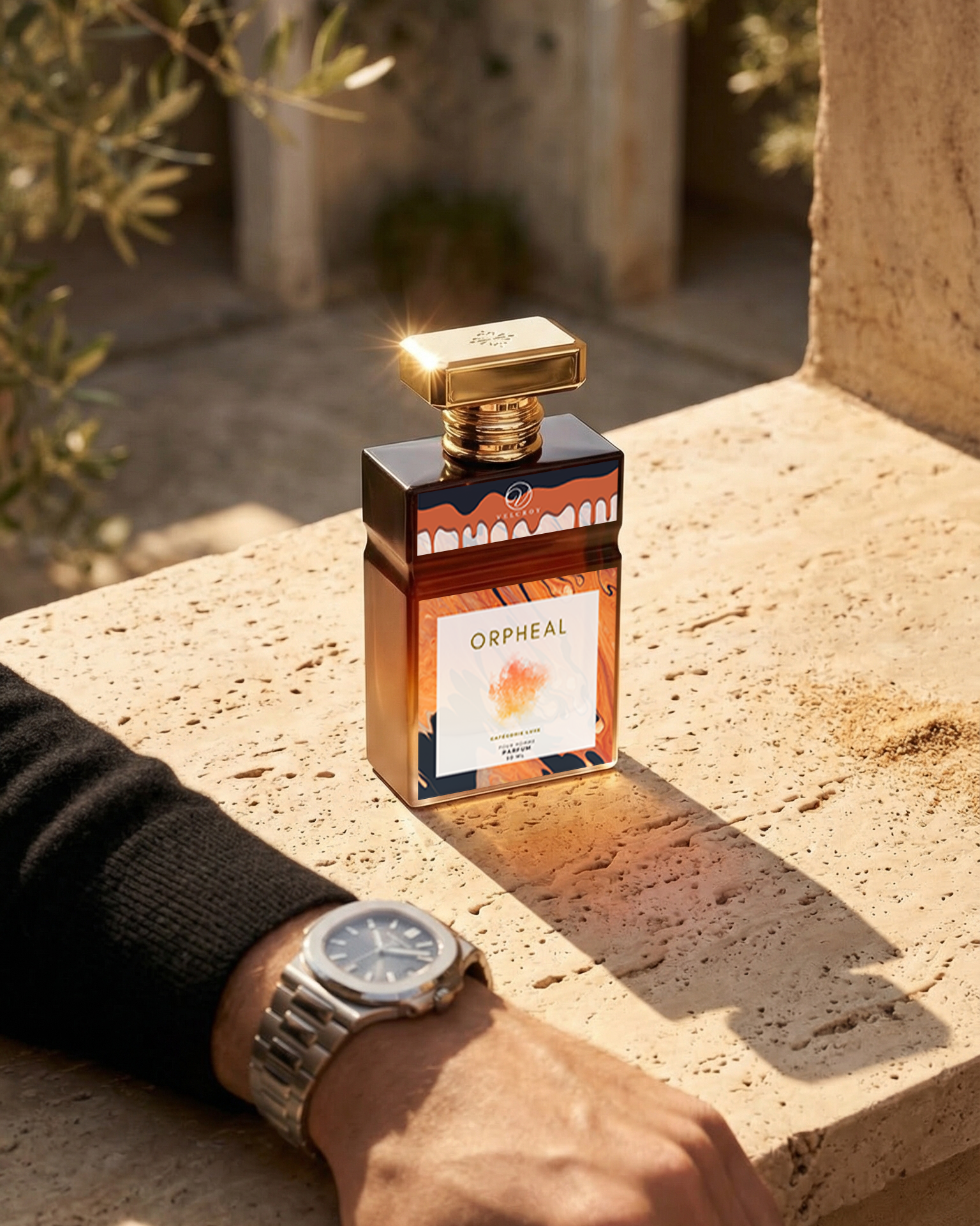 Perfume bottle labeled 'Orpheal' on a stone surface with a hand wearing a watch.