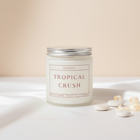 Candle labeled 'Tropical Crush' on a white surface with a beige background