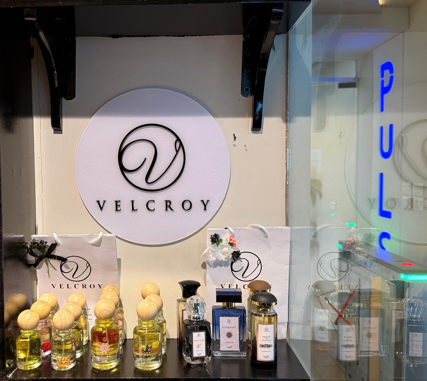 Display of VELCROY perfume bottles and packaging in a store setting.